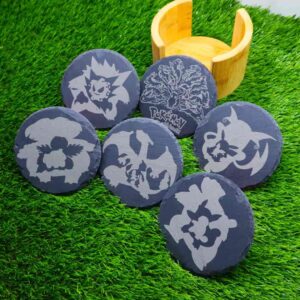 Base de porta-copos de ardósia com design gravado a laser de sombras icônicas de evoluções de Pokémon, incluindo Eevee, Pikachu, Gastly, Bulbasaur, Charmander e Squirtle. Um toque de magia e encanto para qualquer ambiente. Slate coaster base with a laser-engraved design of iconic shadows from Pokémon evolutions, including Eevee, Pikachu, Gastly, Bulbasaur, Charmander, and Squirtle. A touch of magic and charm for any setting.