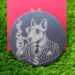 Porta-copos de ardósia com design gravado a laser de um Bull Terrier estiloso, usando terno, óculos escuros, charuto e corrente de ouro com símbolo de dólar. Um toque de atitude e estilo para qualquer ambiente. Slate coaster with a laser-engraved design of a stylish Bull Terrier wearing a suit, sunglasses, cigar, and a gold chain with a dollar sign. A bold and stylish touch for any setting.