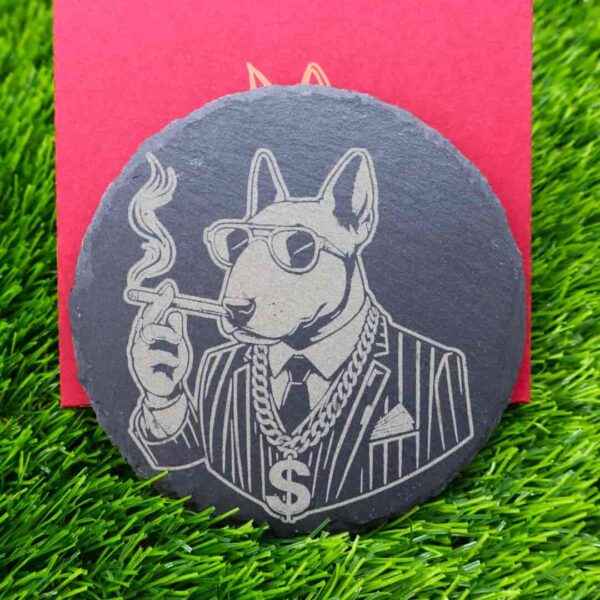 Porta-copos de ardósia com design gravado a laser de um Bull Terrier estiloso, usando terno, óculos escuros, charuto e corrente de ouro com símbolo de dólar. Um toque de atitude e estilo para qualquer ambiente. Slate coaster with a laser-engraved design of a stylish Bull Terrier wearing a suit, sunglasses, cigar, and a gold chain with a dollar sign. A bold and stylish touch for any setting.
