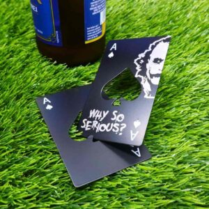 Joker stainless steel bottle opener with engraved spade symbol and 'Why so serious?' phrase, sleek and unique bar accessory. Abridor de garrafas de aço inoxidável com símbolo de espadinha gravado e a frase 'Why so serious?', acessório de bar elegante e único