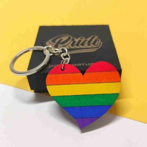 Porta-chaves de madeira em formato de coração arco-íris, simbolizando orgulho, amor e diversidade LGBTQ+, com argola de aço inoxidável. | Rainbow heart-shaped wooden keychain symbolizing LGBTQ+ pride, love, and diversity, with a stainless steel keyring