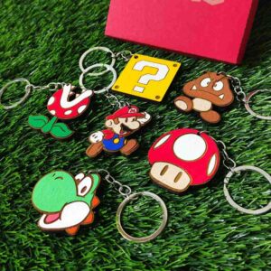Porta-chaves de madeira inspirado em Super Mario, com personagens icônicos pintados à mão, feitos em madeira de reflorestamento e com argola de aço inoxidável. | Super Mario-inspired wooden keychain featuring iconic hand-painted characters, made from reforestation wood with a stainless steel ring.