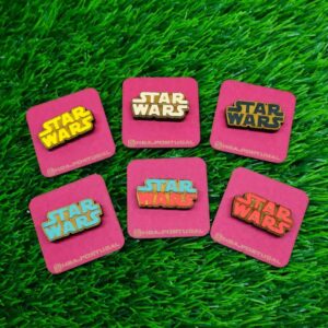 Pins de madeira inspirados na logo de Star Wars, cortados a laser e pintados à mão com detalhes incríveis, Handmade wooden Star Wars logo pins, laser cut and hand-painted with vibrant and precise details.