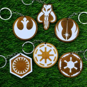 Kit de chaveiros de madeira pintados com os símbolos de Star Wars: Mandalorian, Aliança Rebelde, Império, Jedi, República e Primeira Ordem. Painted wooden keychain set featuring iconic Star Wars logos: Mandalorian, Rebel Alliance, Empire, Jedi Order, Galactic Republic, and First Order.